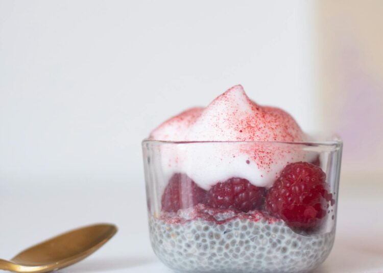 Pudding de chía cremoso con frutos rojos en vaso de cristal listo para desayunar