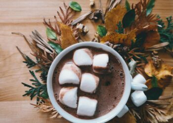 Taza de cerámica blanca con mug cake saludable de cacao y avena recién hecho en el microondas