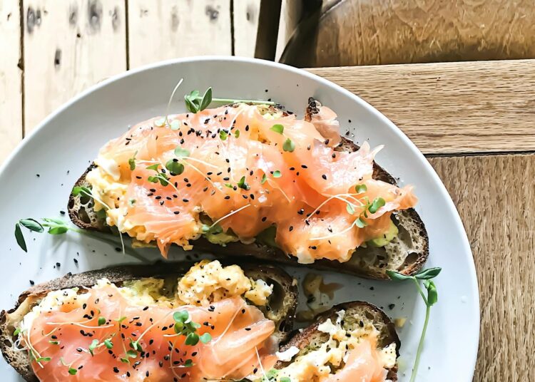 plato con salmón ahumado, huevos y tostadas, alimentos ricos en vitamina D, foto cenital
