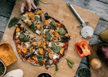 Pizza casera para niños con verduras frescas sobre tabla de madera