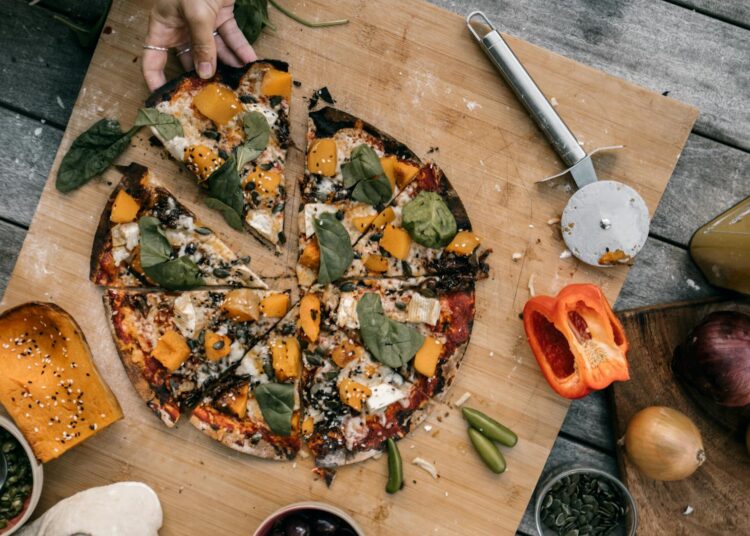 Pizza casera para niños con verduras frescas sobre tabla de madera