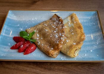 Crepes de avena finos servidos con fruta fresca para un desayuno saludable