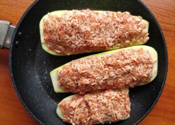 Calabacines rellenos al horno gratinados con queso servidos en una fuente