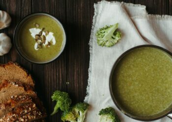 Bol blanco con crema fría de calabacín verde, decorada con un chorrito de aceite y hierbas frescas