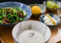 Ensalada de arroz con huevo cocido, maíz y verduras frescas en un bol