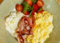 Huevos revueltos cremosos recién hechos servidos en un plato para desayunar