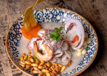 Ceviche peruano recién preparado con pescado blanco, lima, cebolla morada y maíz