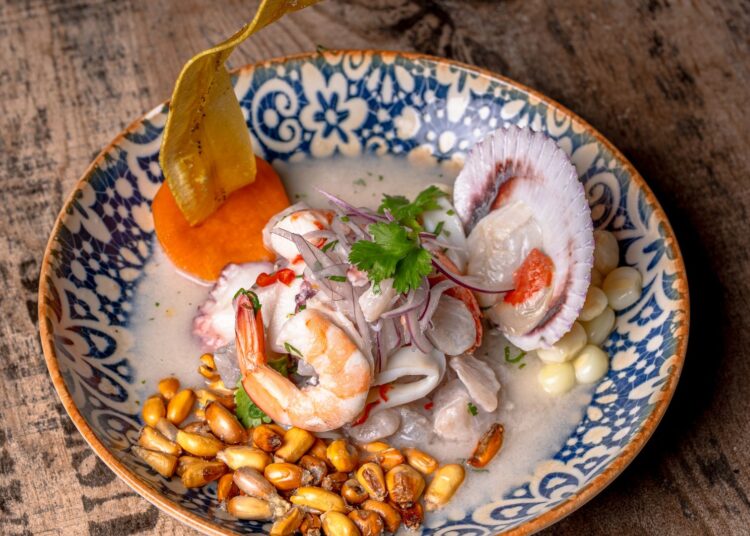 Ceviche peruano recién preparado con pescado blanco, lima, cebolla morada y maíz