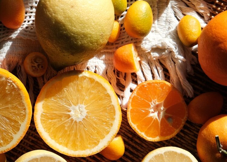 Cesta con alimentos ricos en vitamina C: naranjas, limones, pomelos y otros cítricos frescos