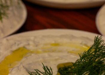 Tzatziki griego cremoso con eneldo fresco y aceite de oliva servido en un plato