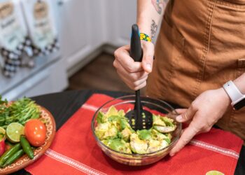 Guacamole casero recién preparado en un bol con aguacate, lima, cebolla y cilantro fresco