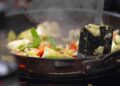 Wok de pollo con verduras salteadas a fuego fuerte en una sartén honda