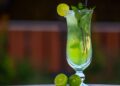 Vaso de mojito sin alcohol con lima, hojas de hierbabuena y hielo picado