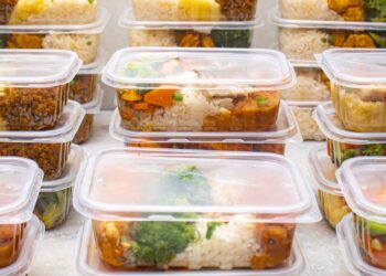 Termos de comida y recipientes con arroz y verduras preparados para llevar el almuerzo