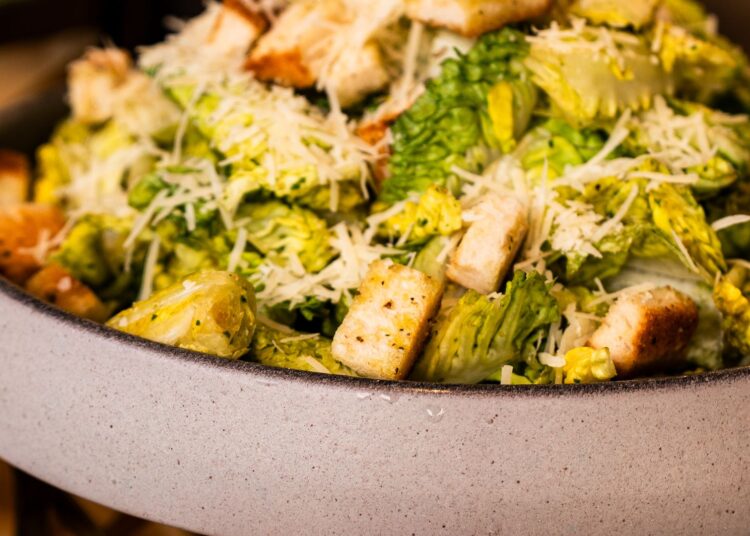 Ensalada César saludable con lechuga romana, picatostes al horno y lascas de parmesano