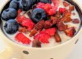 Bol de yogur griego casero cremoso con frutos rojos frescos y cuchara