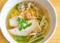 Plato de sopa de fideos casera con caldo de pollo dorado y fideos finos, lista para servir