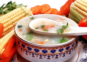 Puré de verduras para niños servido en un bol con zanahoria, calabaza y verduras frescas alrededor