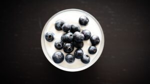 Parfait de yogur con granola y arándanos en un vaso de cristal